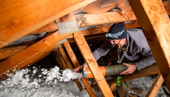 Artisan isole des combles perdus par soufflage de flocons de laine de verre