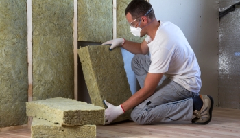 artisan installe panneau isolant mur intérieur